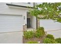 Inviting townhome entrance with stone accents and landscaping, creating a warm and welcoming atmosphere at 5522 Donerail St, Lithonia, GA 30058