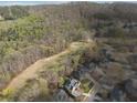 Scenic aerial view showcasing a house nestled among lush trees and a nearby golf course, offering a serene and recreational lifestyle at 6840 N Creekside Pt, Cumming, GA 30041