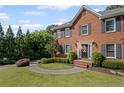 Close up of a charming two-story brick home with a well-manicured lawn and walkway at 1811 Tilliewood Ne Trl, Marietta, GA 30066