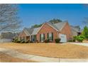 Side view of the attractive brick house with attached garage and manicured landscaping at 5780 Village Loop, Fairburn, GA 30213