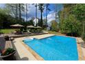 An inviting backyard pool featuring a deck with lounge chairs and manicured landscaping, perfect for relaxation and entertaining at 3811 Valley Green Dr, Marietta, GA 30068
