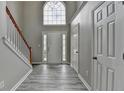 Bright foyer featuring a chandelier, staircase, and beautiful gray wood-look floors at 2274 Stancrest Ln, Lawrenceville, GA 30044