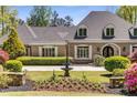 Elegant brick home with manicured lawn, fountain, and flower beds for an inviting curb appeal at 5780 Heards Forest Dr, Atlanta, GA 30328