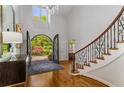 Elegant foyer with dark wood floors, a grand staircase, and custom iron entry doors at 5780 Heards Forest Dr, Atlanta, GA 30328
