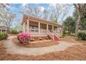 Quaint home featuring a cozy covered porch and a lovely landscaped front yard at 134 N Alexander St, Buford, GA 30518