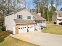 Well-maintained home with a stone-accented garage, charming front porch, and a spacious driveway at 3638 Clubside Nw Walk, Kennesaw, GA 30144