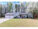 Charming one-story home with a two-car garage and a well-manicured lawn, showcasing its inviting curb appeal at 603 Bluff Dr, Woodstock, GA 30188