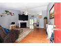 Inviting living room featuring hardwood floors, a cozy fireplace, and a large screen TV at 603 Bluff Dr, Woodstock, GA 30188