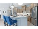Stylish kitchen with a center island, stainless steel refrigerator, custom cabinets and stainless steel appliances at 4220 Provenance Trl, Cumming, GA 30028