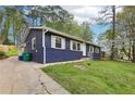 View of the home with driveway and landscaping and mature trees surrounding the property at 2407 Ridgeway Dr, Doraville, GA 30360