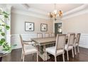 Formal dining room with wainscoting, a modern chandelier, and seating for eight, perfect for entertaining at 2296 Valley Brook Ne Way, Atlanta, GA 30319