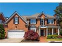 Beautiful brick home featuring a two-car garage, black shutters, and manicured front yard at 2296 Valley Brook Ne Way, Atlanta, GA 30319
