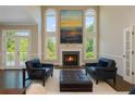 Comfortable living room with fireplace, two chairs, ottoman and large windows with a scenic view at 2296 Valley Brook Ne Way, Atlanta, GA 30319