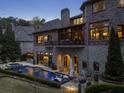 Beautiful backyard oasis featuring a pool with lounge chairs and a covered patio at 290 Ardsley Ln, Alpharetta, GA 30005