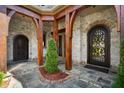 Elegant courtyard with stone floors, wooden beams, and two wrought-iron front doors at 290 Ardsley Ln, Alpharetta, GA 30005