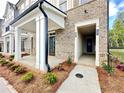 Inviting entryway featuring a covered porch, well-maintained landscaping, and a modern design at 556 Sawnee Village Blvd # D76, Cumming, GA 30040