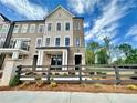 A beautiful townhome exterior showcases brick accents, and a decorative fence, creating curb appeal at 556 Sawnee Village Blvd # D76, Cumming, GA 30040