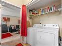 Functional laundry closet with washer, dryer, shelving, and access to a living room space at 313 Daniel Mill Xing, Villa Rica, GA 30180