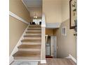 Bright staircase with hardwood steps and neutral walls, leading to an open living space at 313 Daniel Mill Xing, Villa Rica, GA 30180