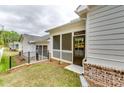 Side view of backyard patio space with a screened in porch and neutral siding at 3904 Shelleydale Dr, Powder Springs, GA 30127