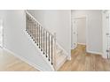 Carpeted staircase with dark metal spindles and light wood handrail at 7194 Brushwood Bend - Lot 116, Lithonia, GA 30058