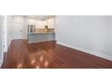 Open-concept living area featuring hardwood floors and a modern kitchen with stainless steel appliances at 1155 Custer Se Ave # 209, Atlanta, GA 30316