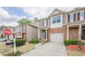 Street view of townhomes with brick accents, attached garages, and well-maintained landscaping at 2705 Maple Park Pl # 29, Cumming, GA 30041