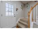Bright entryway with decorative glass door and stairway with white trim and wood railing at 2705 Maple Park Pl # 29, Cumming, GA 30041