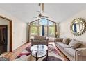 Bright living room featuring a vaulted ceiling, large windows, hardwood floors, and cozy furniture at 5429 Golfcrest Cir, Stone Mountain, GA 30088
