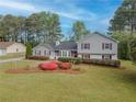 Charming home featuring beautiful landscaping and a well-manicured lawn in a serene, tree-lined neighborhood at 1717 Ramblewood Way, Snellville, GA 30078