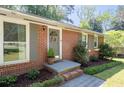 Close-up of a classic brick home entrance, with a welcoming front door and beautifully landscaped walkway at 573 Lyle Se Dr, Marietta, GA 30067