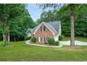 Side view of a brick home with a lush green lawn and tree coverage at 3570 Bulloch Lake Rd, Loganville, GA 30052