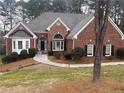 Charming brick home featuring a well-manicured lawn, arched windows, and a welcoming front entrance at 3570 Bulloch Lake Rd, Loganville, GA 30052