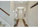 Inviting hallway with hardwood floors, neutral paint, elegant light fixture, and coat rack at 4974 Whiteoak Walk Se # 21, Smyrna, GA 30080