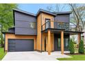 View of a two-story house featuring wooden and grey siding, a balcony, and an attached two-car garage at 1598 Athens Ave, Atlanta, GA 30310