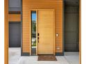Close-up of a modern wooden front door, with a unique design with an adjacent glass panel at 1598 Athens Ave, Atlanta, GA 30310