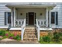 Inviting front porch with stone steps, decorative railings, and classic lighting fixtures at 545 Bellemeade Sw Dr, Marietta, GA 30008