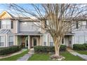 Charming townhome featuring a welcoming porch, landscaped front yard and sidewalk at 109 Odyssey, Conyers, GA 30012
