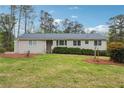 Well-kept single-story home featuring a manicured lawn, tidy shrubbery, and neutral siding under a clear sky at 4151 Valley Wood Nw Dr, Marietta, GA 30064