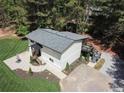 A high-angle view reveals the home's exterior, patio, driveway and surrounding woods at 418 Robinson Rd, Peachtree City, GA 30269
