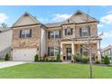 Charming two-story home with brick facade, a two-car garage, and a green lawn at 3610 Central Park Dr, Loganville, GA 30052