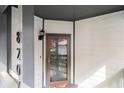 Exterior front door view with the house number, a storm door, and painted wood siding at 8207 Fairview Blf, Alpharetta, GA 30022