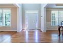 Bright foyer featuring hardwood floors, a white door with decorative glass, and large windows at 5650 Upper Creek Ct, Suwanee, GA 30024