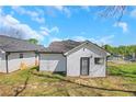 Back exterior of home features tidy grassy yard, black trimmed door, and bright siding at 934 Joseph E Boone Nw Blvd, Atlanta, GA 30314