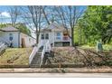 Inviting exterior of a raised cottage home with white stairs leading to a red front door on a treed lot at 944 Joseph E Boone Nw Blvd, Atlanta, GA 30314
