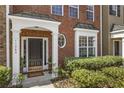 Classic brick front entrance featuring white columns and manicured greenery at 11265 Musette Cir, Alpharetta, GA 30009