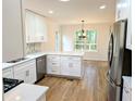 Bright open kitchen with stainless steel appliances, white countertops, and hardwood floors at 2863 Landing Dr, Marietta, GA 30066