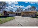 Single-story home with brick and stone facade with an attached garage and long driveway under a partly cloudy sky at 610 Loth Wages Rd, Dacula, GA 30019