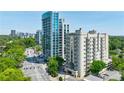 Condo building exterior view surrounded by lush greenery and cityscape at 2161 Peachtree Ne Rd # 907, Atlanta, GA 30309