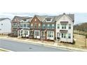 Row of newly built townhomes with brick and painted exteriors, and well-maintained front yards at 4209 Tifton Ln, Sugar Hill, GA 30518